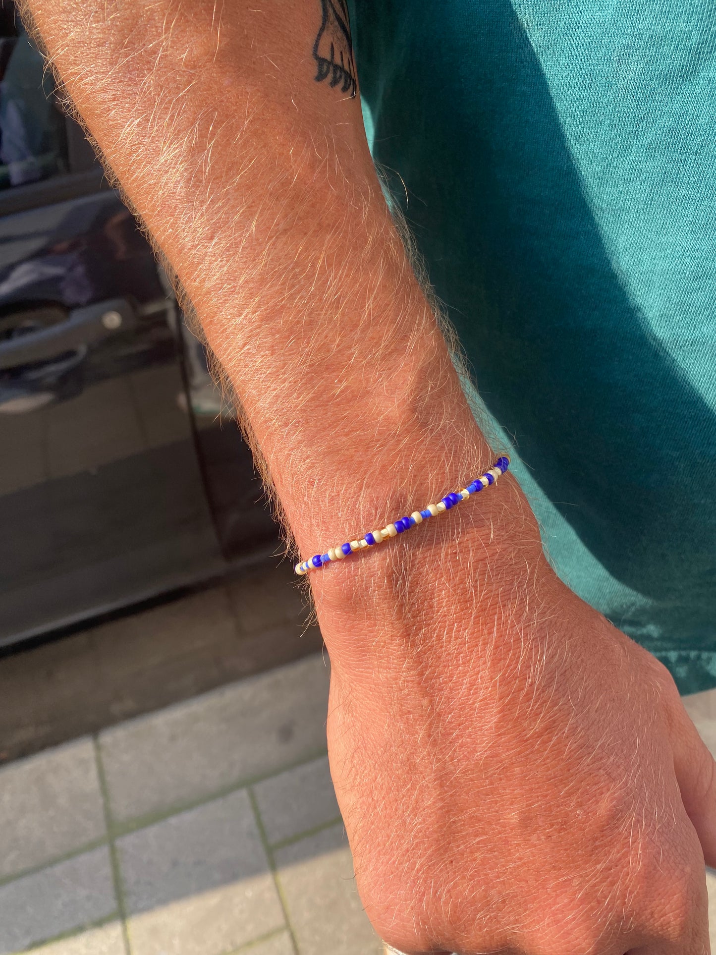 The beaded men's Bracelet is crafted with subtle beige and blue beads on a stretch band, making it easy to slip on and off without a clasp. With its fine, lightweight beads, it’s perfect for adding a touch of style to any outfit, all year round. 