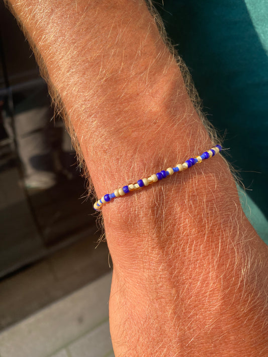 The beaded men's Bracelet is crafted with subtle beige and blue beads on a stretch band, making it easy to slip on and off without a clasp. With its fine, lightweight beads, it’s perfect for adding a touch of style to any outfit, all year round. 