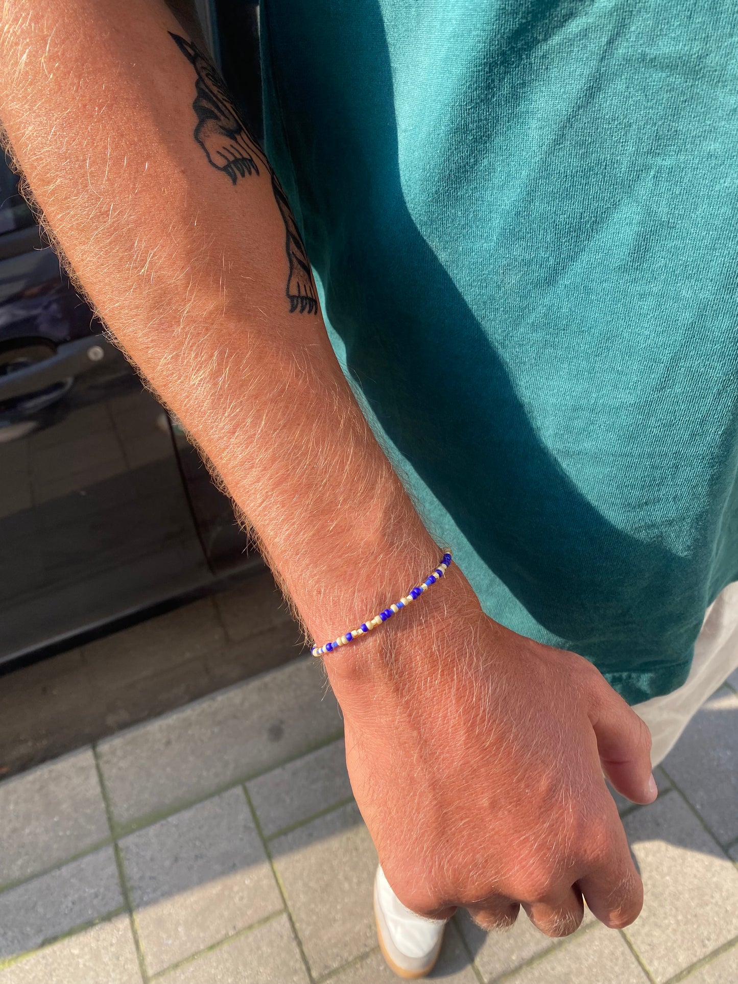The beaded men's Bracelet is crafted with subtle beige and blue beads on a stretch band, making it easy to slip on and off without a clasp. With its fine, lightweight beads, it’s perfect for adding a touch of style to any outfit, all year round. 